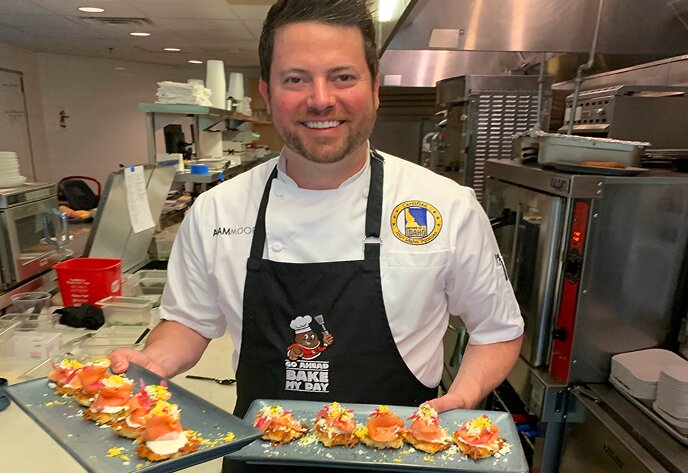 A chef in the kitchen holding trays of Idaho® potato appetizers