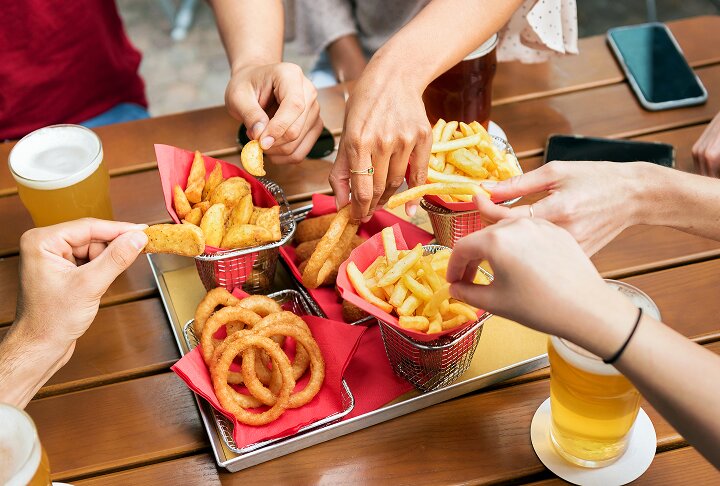 Friends sharing baskets of Idaho® potato fries and onion rings